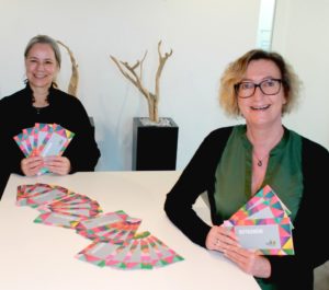 Zwei Frauen zeigen Einkaufsgutscheine in die Kamera