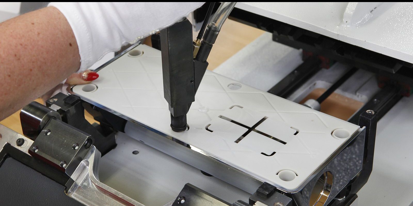 HDO Mitarbeiterin arbeitet mit einer Maschine an einer weißen Platte