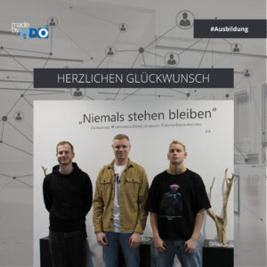 Drei junge Männer stehen vor einer Wand mit dem Zitat ‚Niemals stehen bleiben‘ und dem Text ‚Permanente Weiterentwicklung ist unsere Unternehmensmaxime.‘, darüber steht ‚Herzlichen Glückwunsch‘, im Hintergrund grafische Vernetzungs-Symbole und das Logo von HDO mit dem Hashtag #Ausbildung.